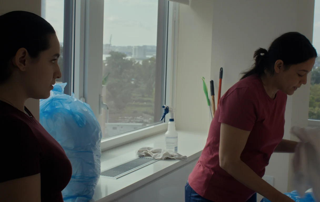 Cristina Villalobos and Gredivel Vasquez clearing a high-rise hotel room in a scene from the 2026 short film In Sanctuary