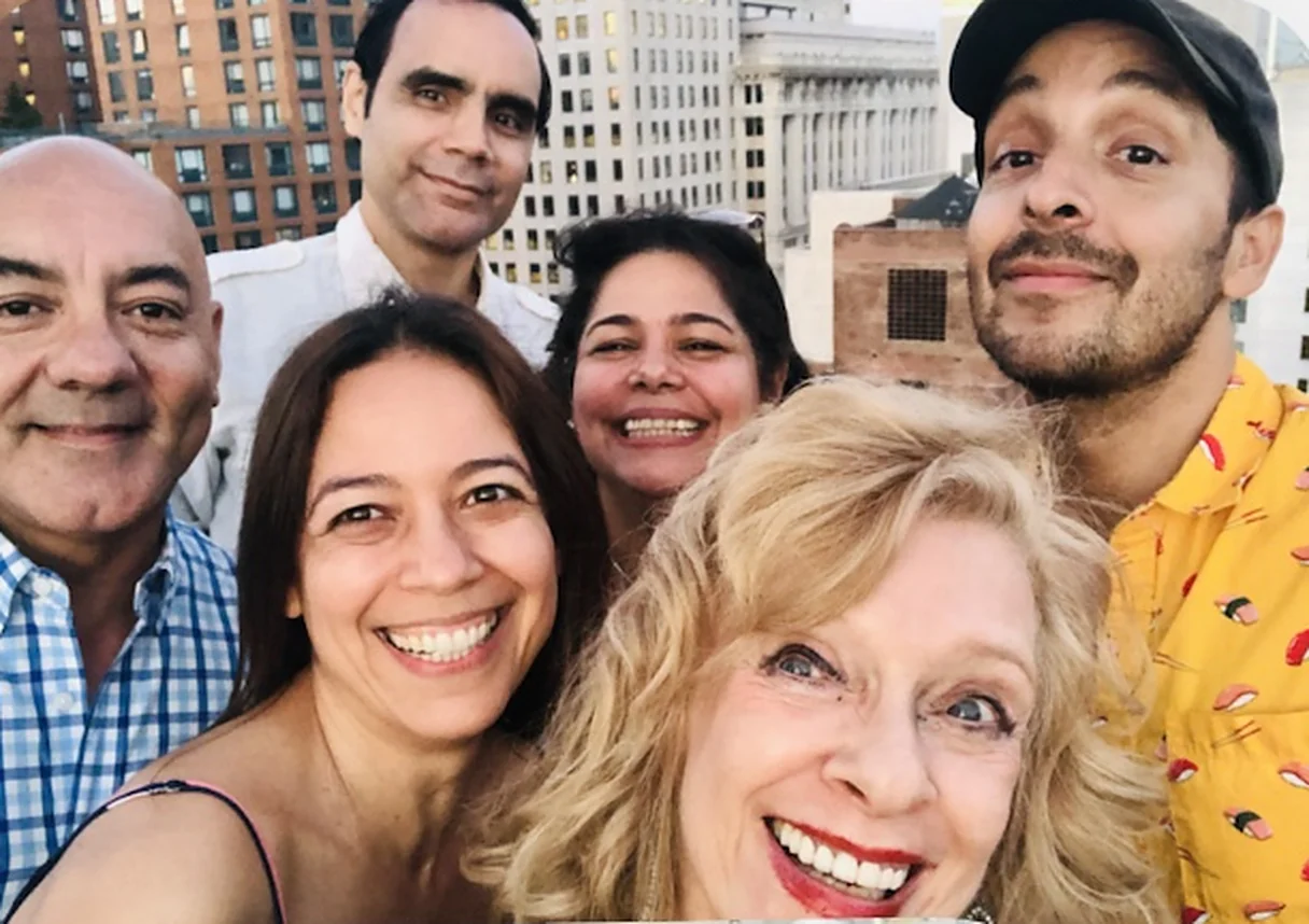 Gredivel Vasquez and Alicia Kaplan smiling in a rooftop selfie with the cast and creative team of Vistiendo Santos in New York